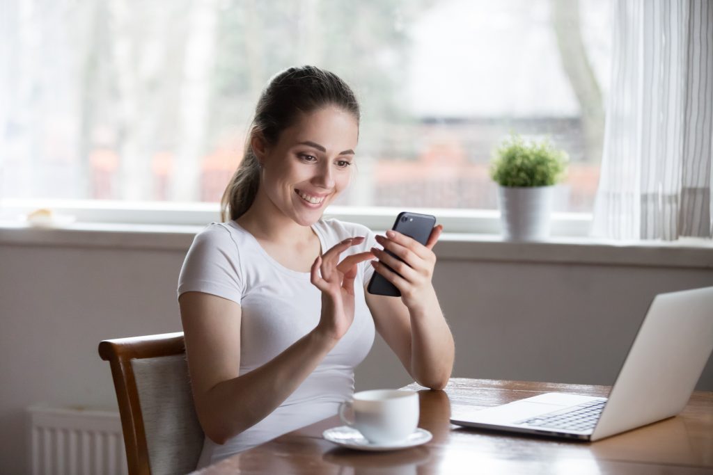 telefonuna bakıp gülümseyen kadın